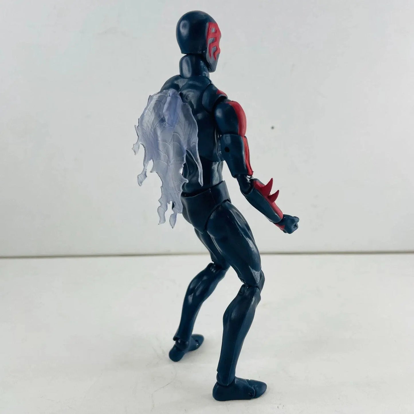 Black and red action figure with translucent tattered cape on plain white background