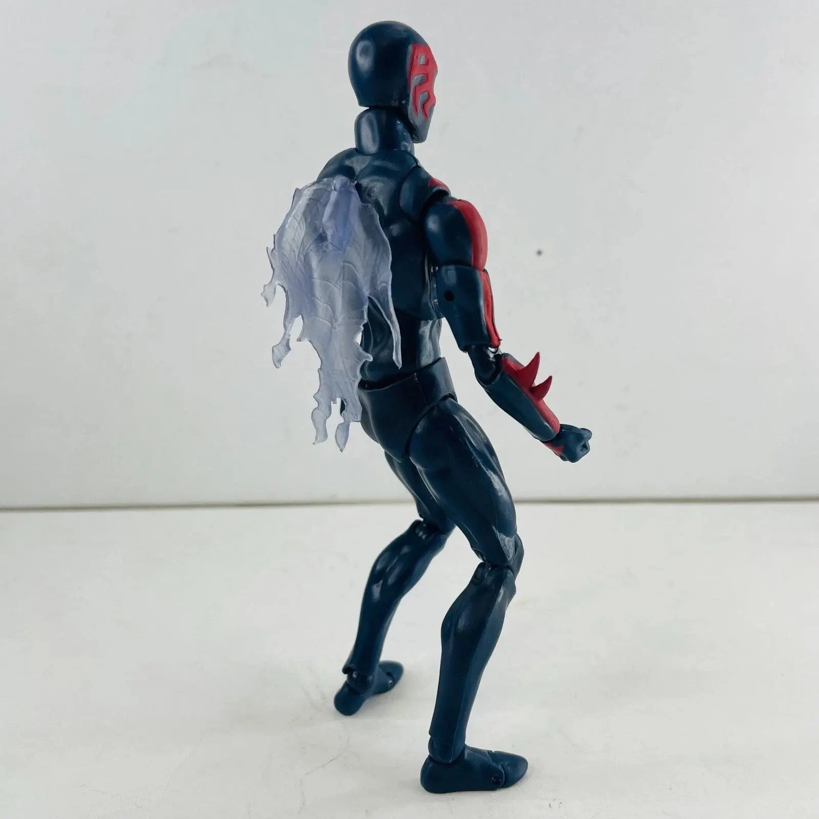 Black and red action figure with translucent tattered cape on plain white background