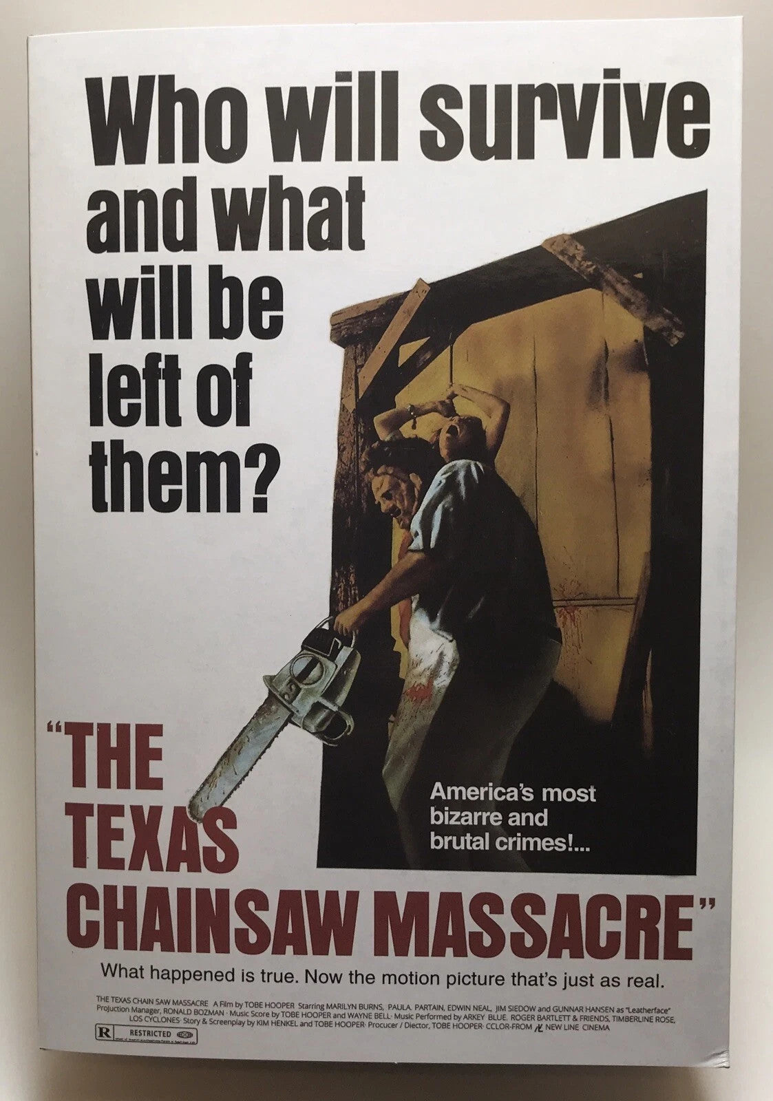 The Texas Chainsaw Massacre movie poster with horror image of man holding chainsaw and woman tied up