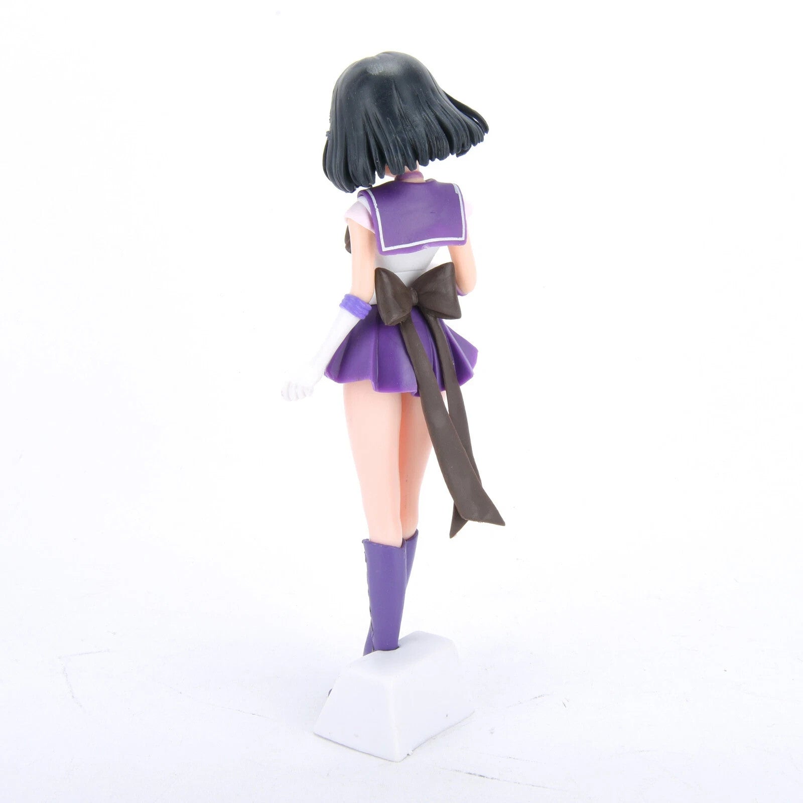 Back view of anime girl figure in purple sailor school uniform with black bow and boots on white base