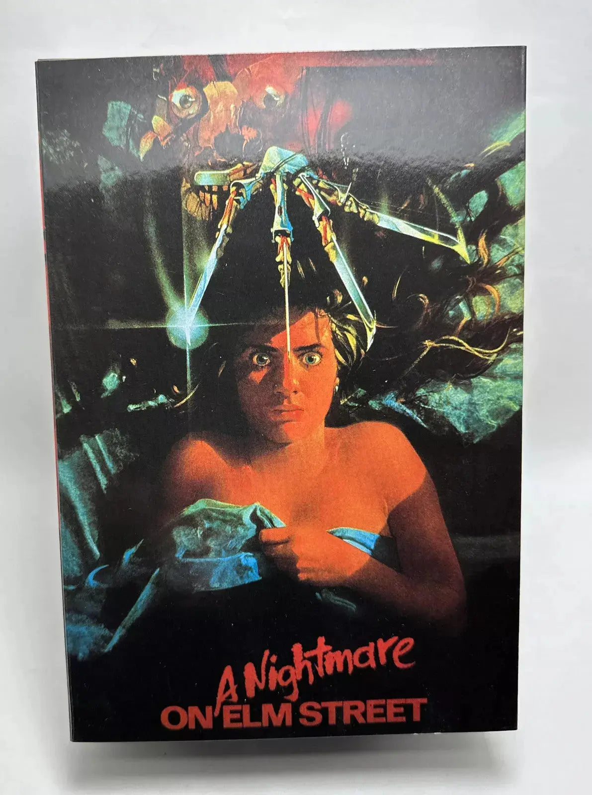 A Nightmare on Elm Street VHS cover featuring a scared woman with Freddy Krueger's claw glove above her head