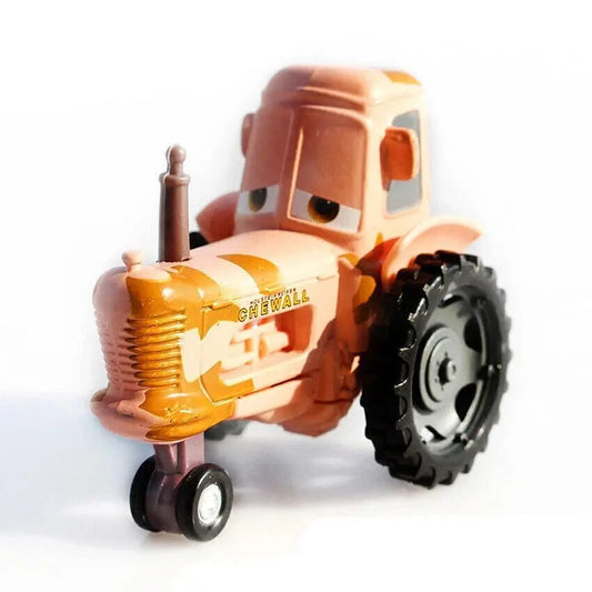 orange toy tractor with cartoon eyes and large black rear tire on white background