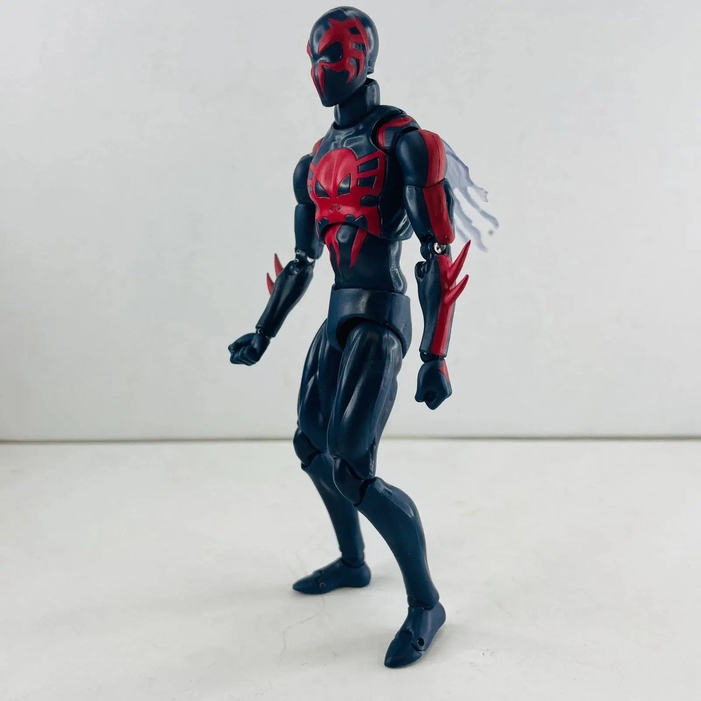 Black and red action figure with spider design and clawed forearms on white background