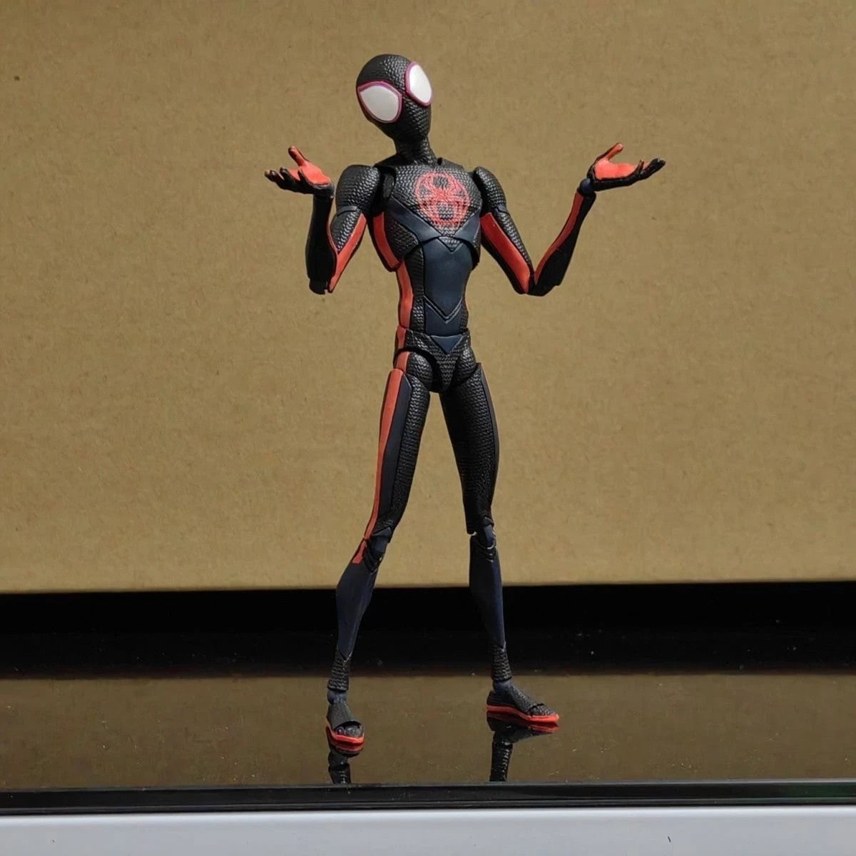 Spider-Man Miles Morales action figure in black and red suit posed with arms raised
