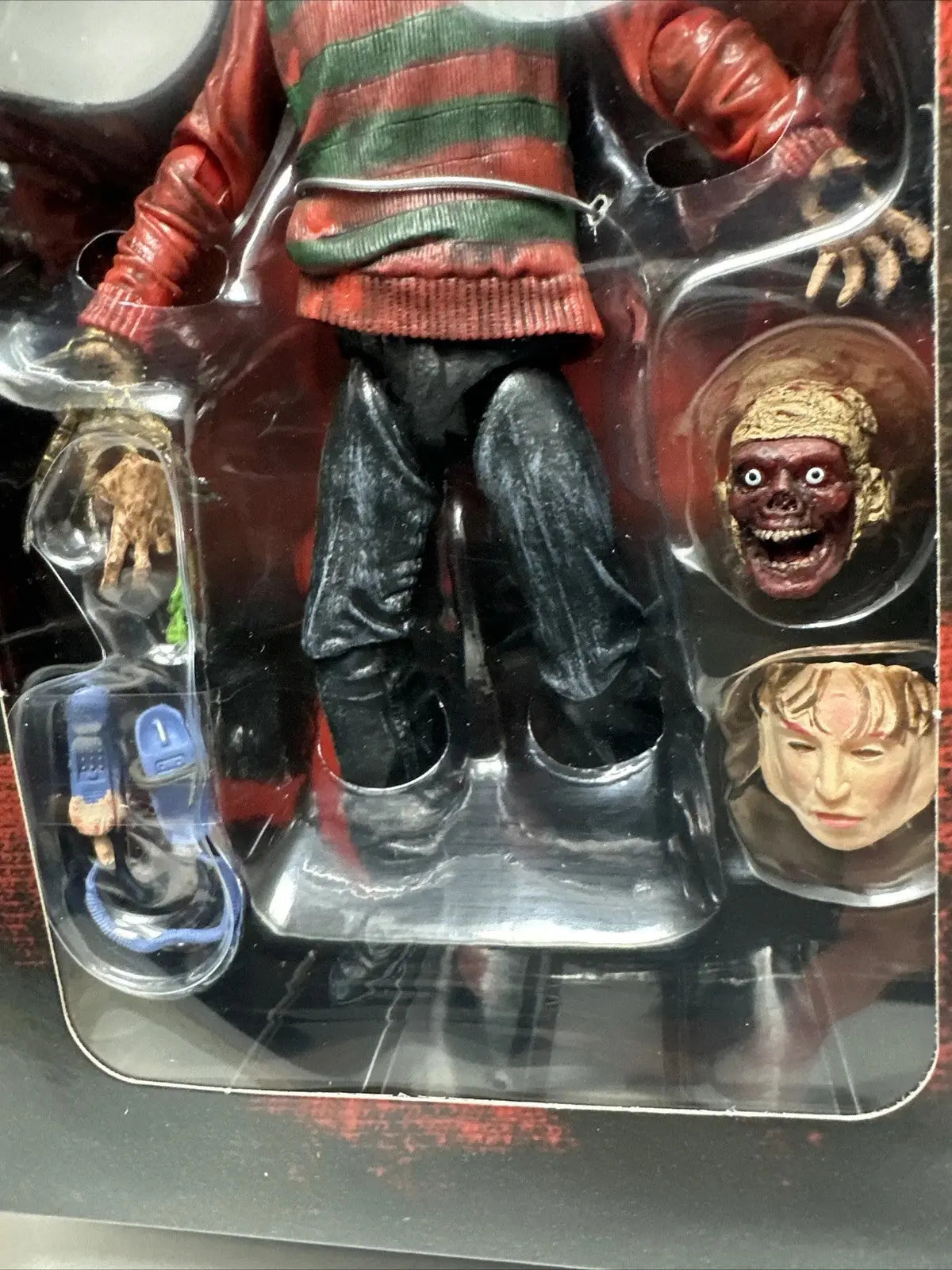 Action figure wearing striped sweater and black pants with interchangeable zombie and human heads